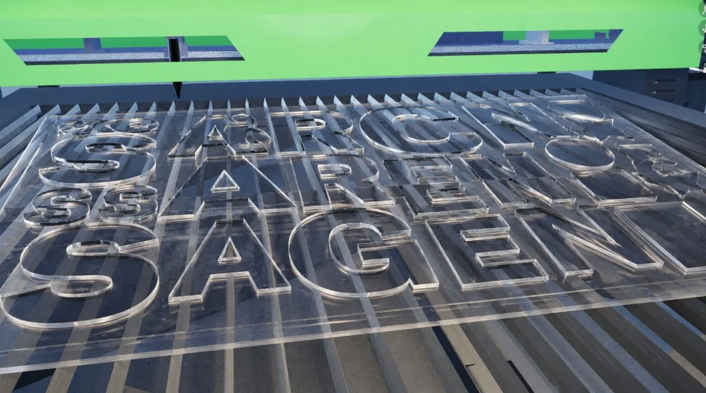 Clear acrylic sign letters nested across a CO₂ laser cutting bed