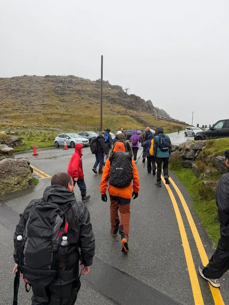 Three Peaks participants beginning a stage of the challenge on a wet mountain road