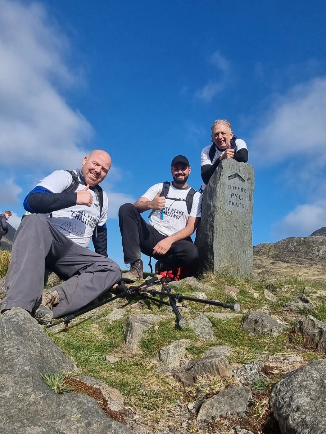 Mantech team posing by the Llwybr Pyg Track stone marker on the Snowdon route