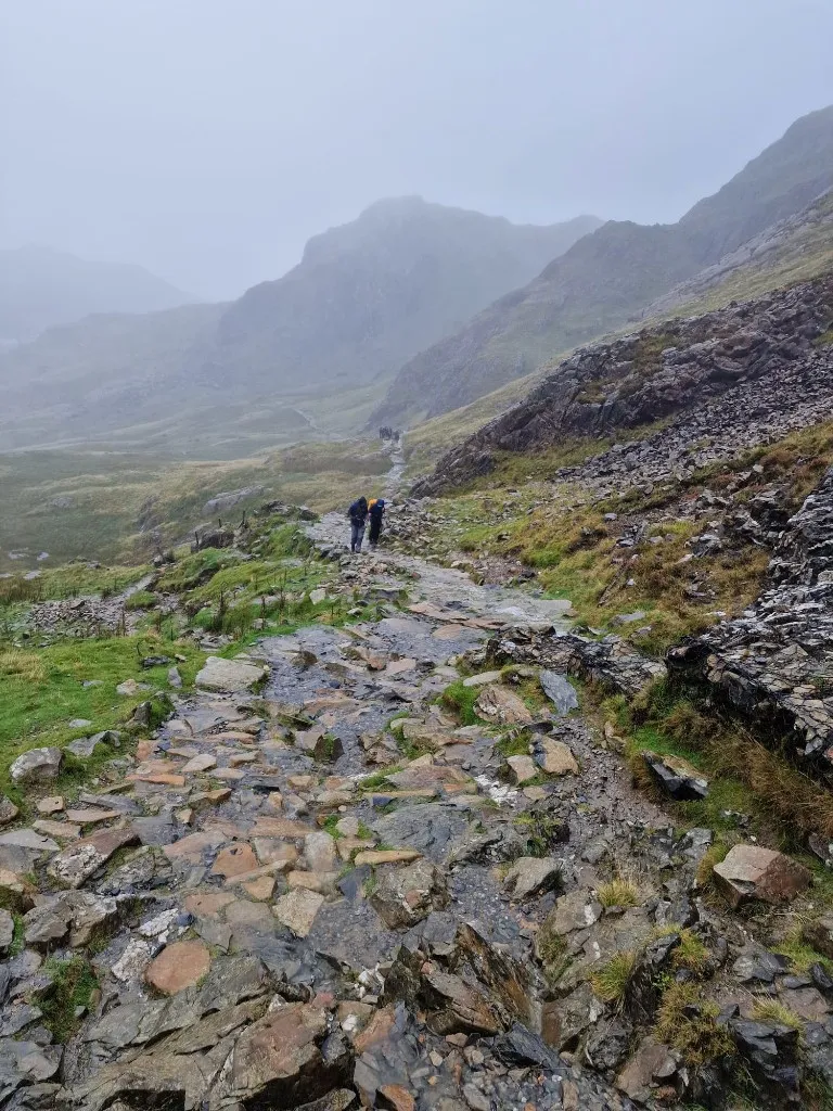 A wet rocky mountain path stretching into the mist during the challenge