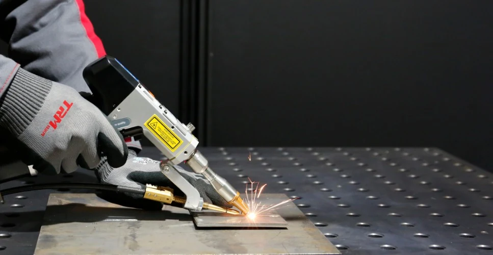 Handheld TRM fibre laser welding in progress with sparks at the joint